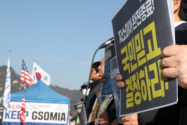 아베규탄시민행동 회원들이 22일 오후 서울 광화문 광장에서 손팻말을 들고 한일 군사정보보호협정 (GSOMIA·지소미아) 폐기를 촉구하는 기자회견을 진행하고 있다. 뒷편으로 우리공화당이 설치한 지소미아 유지를 촉구하는 현수막이 걸려있다. 지소미아는 오는 22일 자정 종료를 앞두고 있다.
