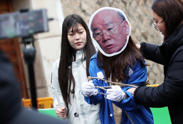23일 오후 서울 마포구 전두환 전 대통령 자택 앞에서 열린 '전두환 규탄 및 단죄를 위한 대학생 기자회견'에서 참석자들이 전두환 구속 수사를 촉구하는 퍼포먼스를 하고 있다.