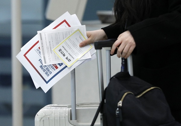 독일 프랑크푸르트에서 온 입국자가 28일 인천국제공항에서 검역확인증을 들고 별도 교통편을 이용하기 위해 이동하고 있다.