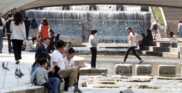초여름 날씨를 보인 6일 서울 청계천에서 시민들이 더위를 식히고 있다. 이날 낮기온은 서울과 대전 28도 대구 26도 부산 22도로 어제보다 3도에서 9도가량 높게 나타났다.