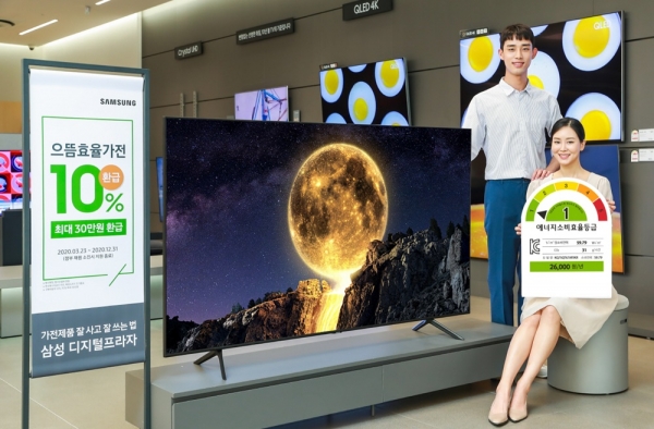 삼성전자 모델이 삼성디지털프라자 강남본점에서 에너지 소비효율 1등급을 받은 QLED TV를 소개하고 있다.