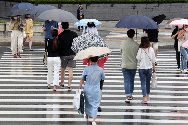 전국에 장맛비가 내린 27일 오후 서울 중구 동대문역사문화공원역 앞에서 우산을 쓴 시민들이 발걸음을 재촉하고 있다.