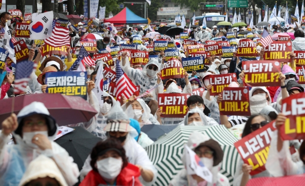 자유연대 및 집회 참가자들이 8일 오후 서울 종로구 경복궁 인근에서 정부 정책을 규탄하며 손팻말을 들고 있다.