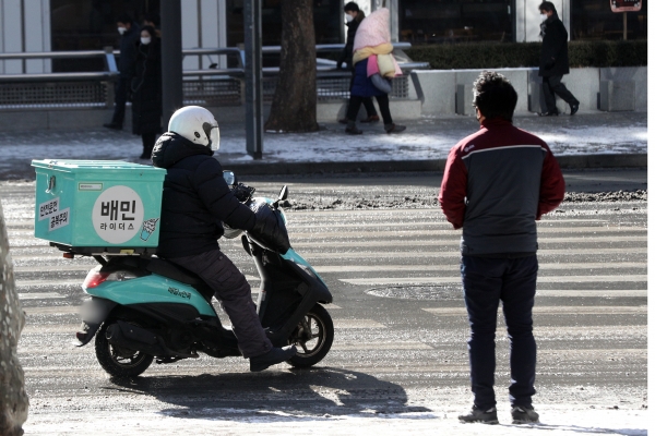 1월7일 서울 종로구청 앞에서 배달 노동자가 도로를 주행하고 있다. 2021.1.7 (사진 뉴스1)