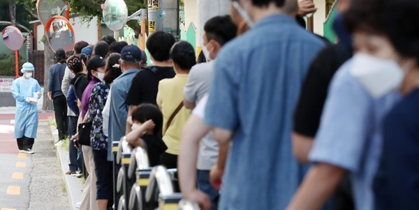 23일 오전 서울 구로구 보건소에 마련된 코로나19 선별진료소에서 시민들을 비롯한 국내 거주 외국인 노동자들이 코로나19 진단 검사를 받기 위해 길게 줄을 서 있다.