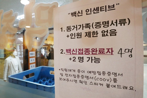 서울 한 식당에 백신 접종 인센티브에 따른 모임인원 완화 관련 안내문이 붙어 있다.