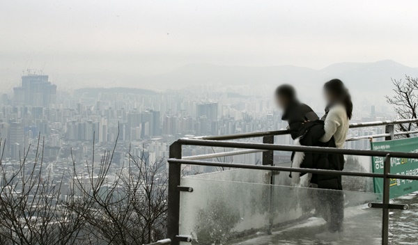 서울의 미세먼지 농도가 '나쁨'을 보이고 있는 지난 2일 오전 서울 남산을 찾은 시민들이 눈 덮인 도심을 보고 있다.