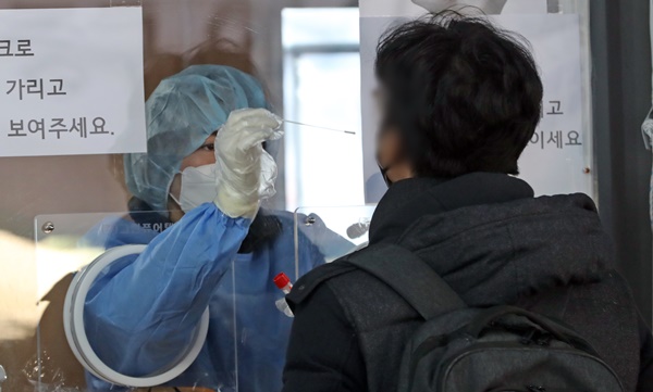 21일 오전 서울역 선별진료소에서 시민이 코로나19 검사를 받고 있다. 최근 오미크론 변이 바이러스의 급속한 확산으로 코로나19 하루 확진자가 7000명에 육박할 것으로 예측되고 있다. 