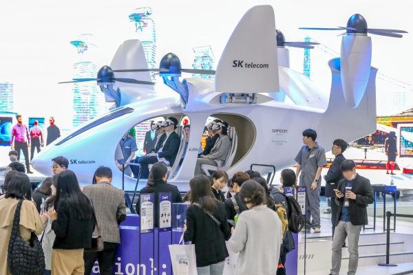 서울 강남구 코엑스에서 지난달 19일 열린 '2023 월드IT쇼'를 찾은 관람객들이 SK텔레콤의 도심항공교통(UAM) 체험을 하고 있다.