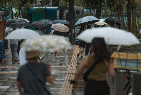 사진- 중부지방의 태풍 특보가 해제된 11일 오후 서울 종로구 광화문 사거리 인근에서 우산을 쓴 시민들이 발걸음을 재촉하고 있다. 2023.8.11/뉴스1