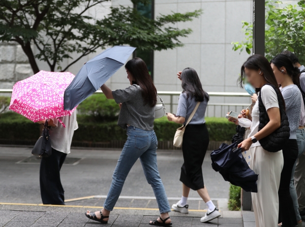사진 - 22일 서울 종각역에서 시민들이 비가 내리자 우산을 펴고 있다. 기상청은 이날 서쪽 지방을 시작으로 중부와 호남 지방에 비가 내리다가 내일은 전국으로 확대될 것으로 예보했다. 2023.8.22/뉴스1
