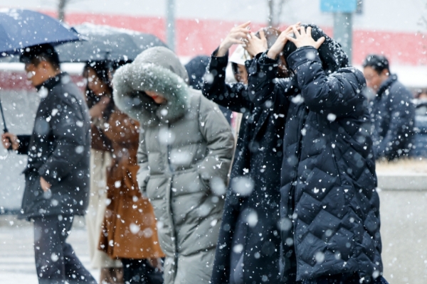 서울 지역에 눈이 내리는 17일 여의도에서 직장인들이 점심식사를 하기 위해 이동하고 있다.