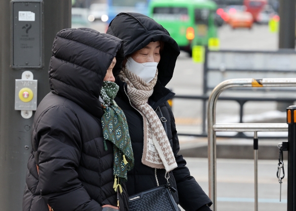 눈과 비가 그치고 쌀쌀한 아침기온을 보인 23일 오전 서울 종로구 광화문 네거리에서 두터운 옷을 입은 시민이 발걸음을 재촉하고 있다.