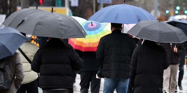 이른 봄비가 내린 2월 21일, 서울 광화문네거리 인근에서 우산 쓴 시민들이 출근길 발걸음을 옮기고 있다.