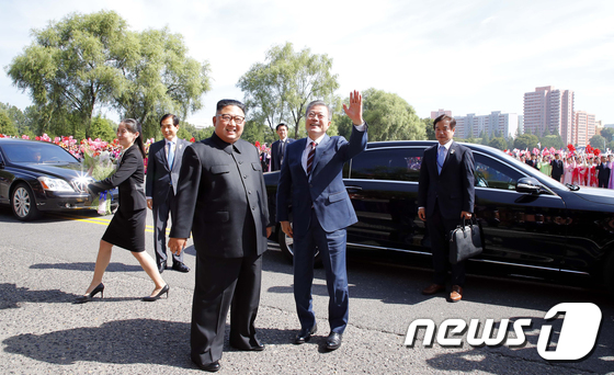 문재인 대통령과 김정은 북한 국무위원장이 18일 평양 시내 카퍼레이드를 하기 전 평양시민들을 향해 손을 흔들고 있다.