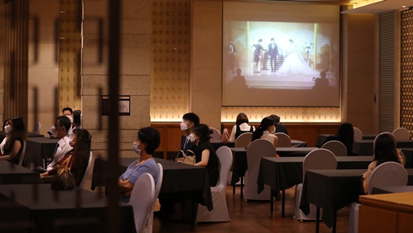 지난해 8월 23일 서울 시내의 한 대형 웨딩업체 웨딩홀에서 하객들이 온라인 화면으로 결혼식을 지켜보고 있다. / 사진 = 뉴스1