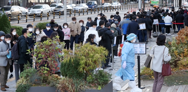 22일 오전 서울 송파구 보건소에 마련된 선별진료소를 찾은 시민들이 길게 줄을 서 검사 차례를 기다리고 있다.