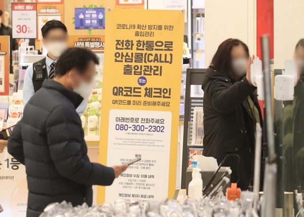 서울 내의 3천㎡ 이상 상점·마트·백화점에 적용한 방역패스 조치의 효력 정지 결정이 나온 가운데 16일 서울 한 대형마트에서 시민들이 QR코드 체크를 하고 있다. 