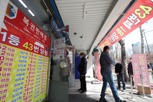 16일 오전 서울 노원구의 복권판매점 앞에 복권을 사기 위한 시민들이 줄을 서 있다.  2021.3.16