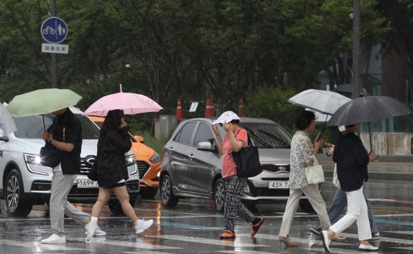 사진 -23일 서울 광화문 네거리에서 우산을 준비하지 못한 시민이 신문지로 얼굴을 가린 채 횡단보도를 건너고 있다. 기상청은 내일까지 전국 대부분 지역에 50~120mm, 많은 곳은 최고 150mm 이상의 호우가 쏟아질 것으로 예보했다. 2023.8.23/뉴스1 