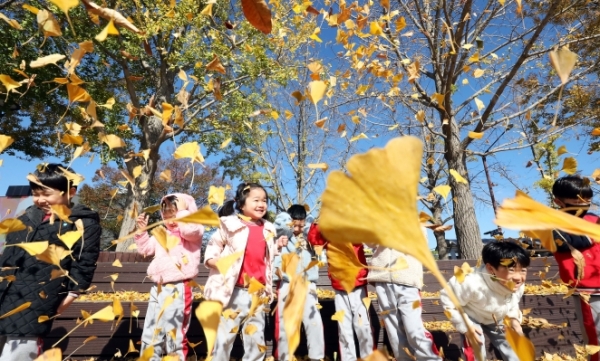 10일 충남 아산시 염치읍 곡교천 은행나무길을 찾은 어린이들이 쌀쌀해진 날씨에도 불구하고 떨어진 은행잎을 머리 위로 던지며 마지막 가을 나들이를 즐기고 있다.